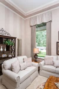 Custom drapes and top treatment add softness and color to this living room, while offering privacy.